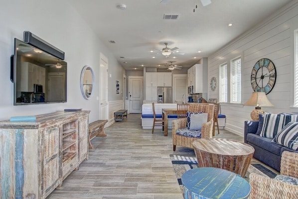 Relax in this stylish living area with a modern kitchen, featuring a large mirror, comfortable sofa, and round coffee table.