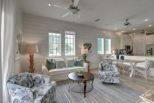 Relax in this spacious living room with a central seating area, sofa, and armchairs, perfect for unwinding.
