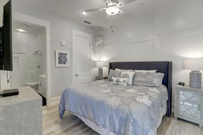Relax in a serene bedroom with a large bed, bedside tables, and a ceiling fan.