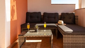 A cozy seating area with a sofa and two small tables, each with a glass of orange juice. - 1 bedroom nice apartment in Podgradina (Podgradina)