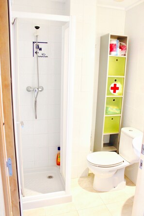 Un bagno con doccia, toilette e mobile contenitore.