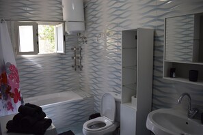 Ein Badezimmer mit Badewanne, Toilette und Waschbecken.