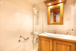Baignoire, séchoir à cheveux, papier de toilette