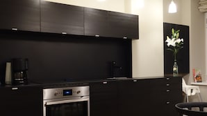 Una cucina moderna con mobili scuri, forno integrato e una finestra con vista.