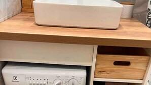 A compact washing machine with a control panel, a sink, and wooden storage drawers in a small laundry area. - T2 / 3, heart of resort, bottom of slopes, parking, 30m3 + 100m2 terrace (Mont-de-Lans)