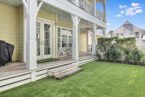 A house with a covered porch, a lawn, and a deck.