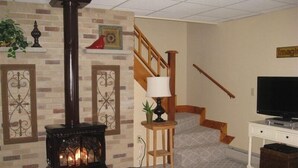 A living room with a fireplace, a television, and a staircase.