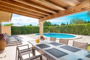 An outdoor patio with a pool, wooden pergola, and seating area. - FANTASTIC VILLA WITH POOL (Pollença)