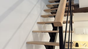 A wooden staircase with black metal railings in a modern interior. - Les Temps Perdus (Prehy)