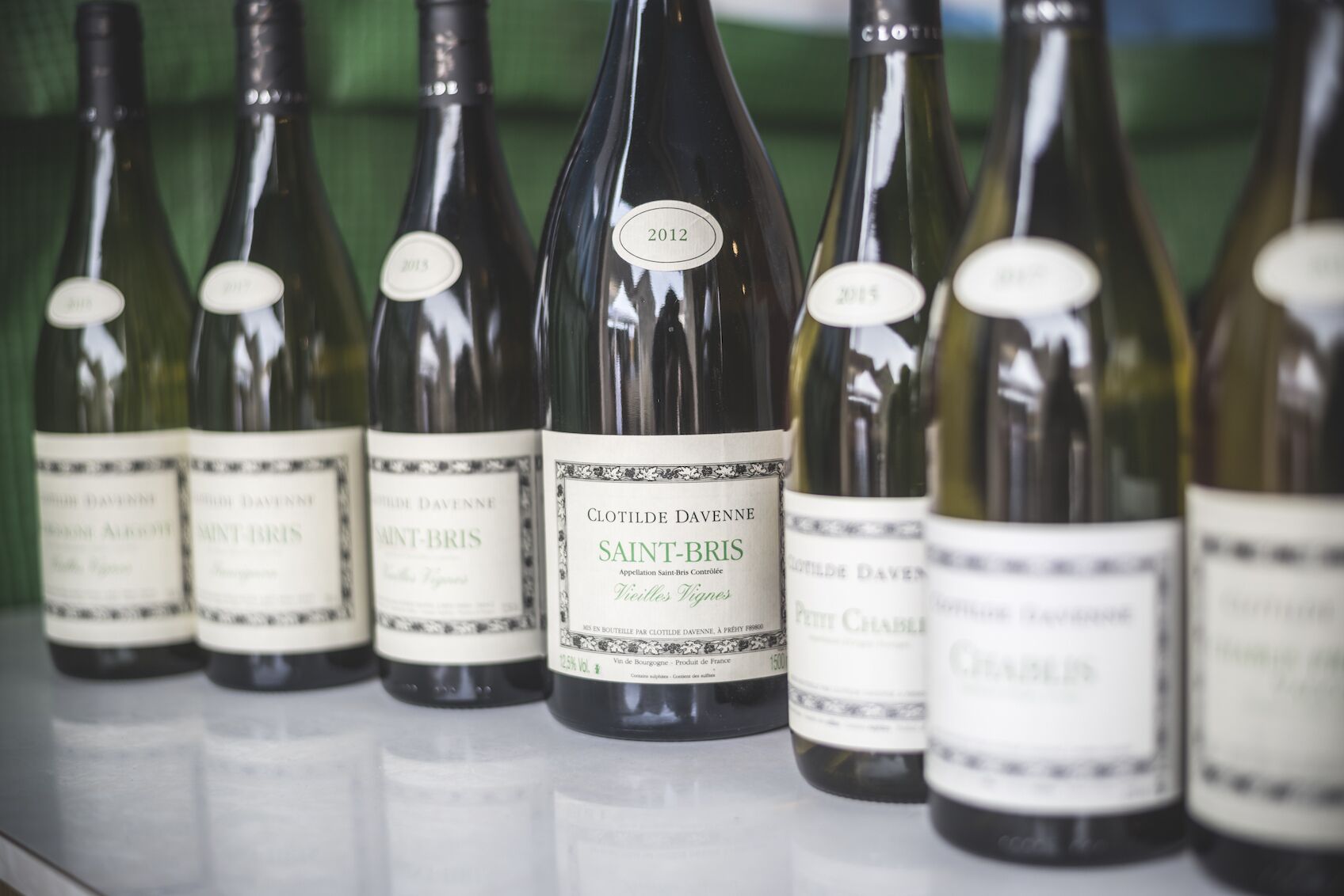 A row of wine bottles with labels, including one marked 2012.