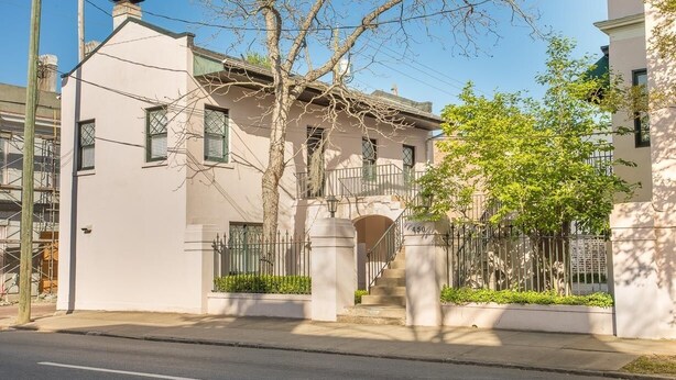 A two-story building with a balcony, a staircase, and a gated entrance. - Intimate Getaway for Two, Steps from Forsyth Park by Lucky Savannah (Savannah)
