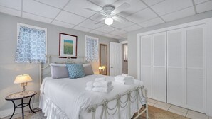 A bedroom with a bed, a ceiling fan, a bedside table with a lamp, and a wardrobe. - Intimate Getaway for Two, Steps from Forsyth Park by Lucky Savannah (Savannah)