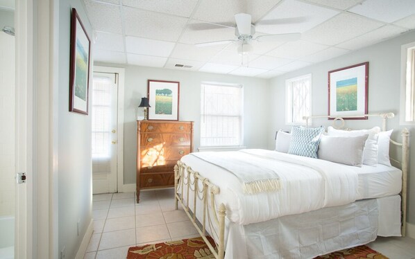 A bedroom with a bed, dresser, and ceiling fan. - Intimate Getaway for Two, Steps from Forsyth Park by Lucky Savannah (Savannah)
