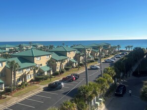 Ein Küstenhotel mit mehrstöckigen Gebäuden, einem Parkplatz und Blick auf das Meer.