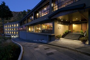 A modern hotel with a two-story structure, large windows, and a well-lit entrance.