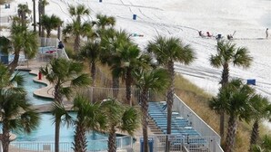 Ein Resort mit Schwimmbad, Palmen und Strand.