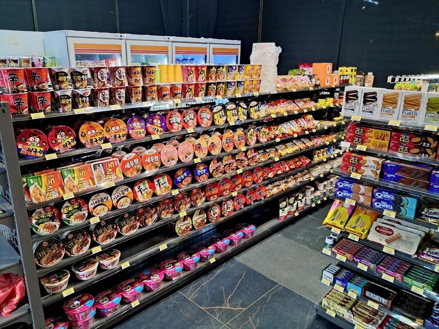 Ein Gang in einem Supermarkt mit verschiedenen verpackten Lebensmitteln und Snacks.