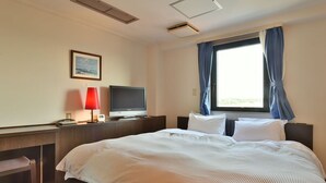 A hotel room with a large bed, a desk with a computer, a TV, and a window with curtains. - Suzuka Royal Hotel (Suzuka)