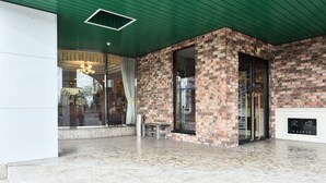 A modern building with a green ceiling, brick walls, and a marble floor. - Suzuka Royal Hotel (Suzuka)