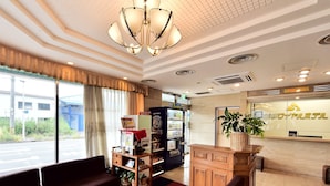 A hotel lobby with a reception desk, seating area, coffee machine, and a large window. - Suzuka Royal Hotel (Suzuka)