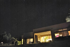A modern building at night with a starry sky.