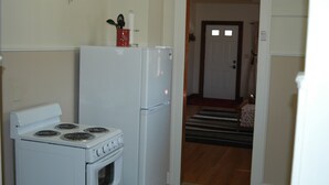 A kitchen with a stove, refrigerator, and a red cup holder on the fridge. - Bethany Bungalow, 2 Bdrm, 1 Bath bungalow near all Husker events (Lincoln)