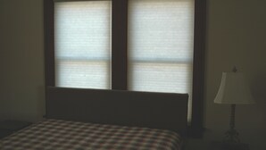 A room with a bed, a nightstand, and a lamp. - Bethany Bungalow, 2 Bdrm, 1 Bath bungalow near all Husker events (Lincoln)