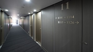 Ein Flur mit Türen, nummeriert von 1111 bis 1114 und von 1115 bis 1126, typisch für ein Hotel oder eine ähnliche Unterkunft.
