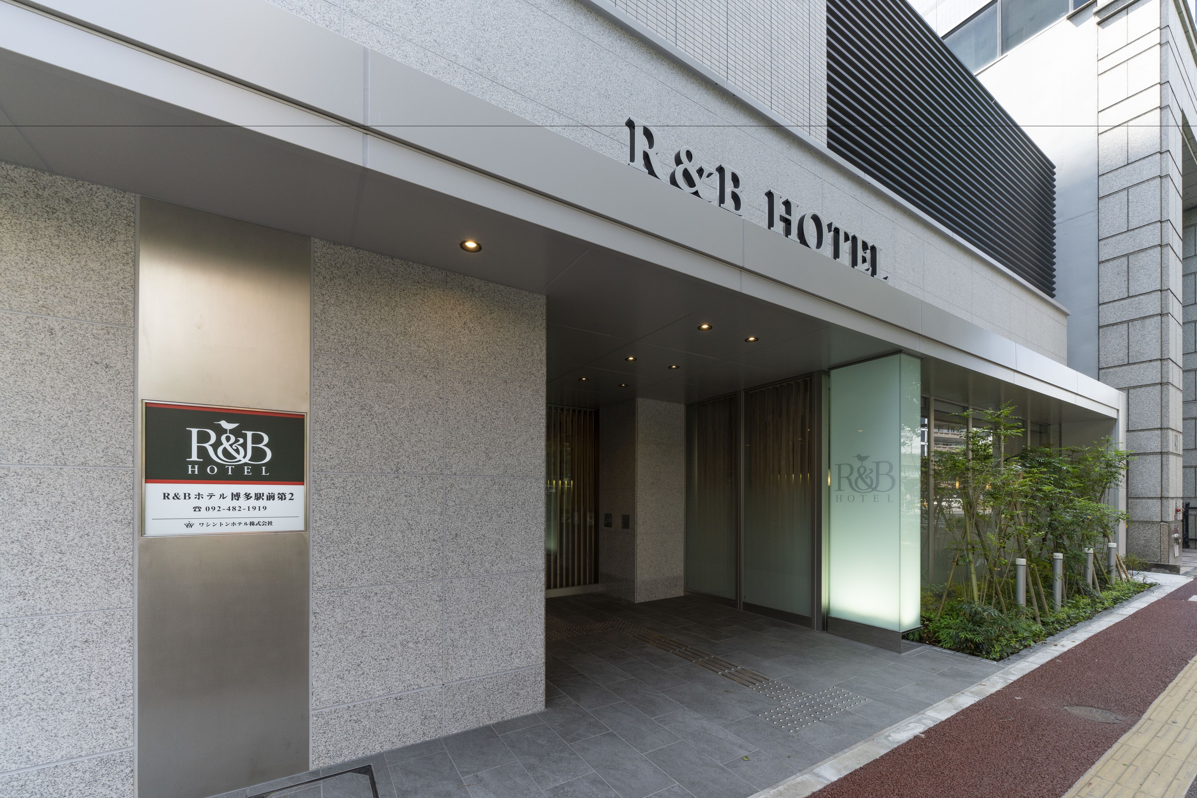 The exterior of the R&B Hotel with a modern facade, large glass windows, and a signboard.