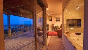Un intérieur moderne avec un balcon donnant sur une vue panoramique de la ville au crépuscule.