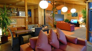 Una sala de estar acogedora con un sofá, una mesa de comedor y un televisor.