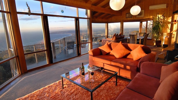 Amplia sala de estar con un ventanal que ofrece una vista panorámica de la ciudad y la costa.
