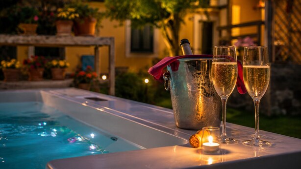 Ein Poolbereich mit Champagnerkühlbagger, zwei Gläsern und einer Kerze.