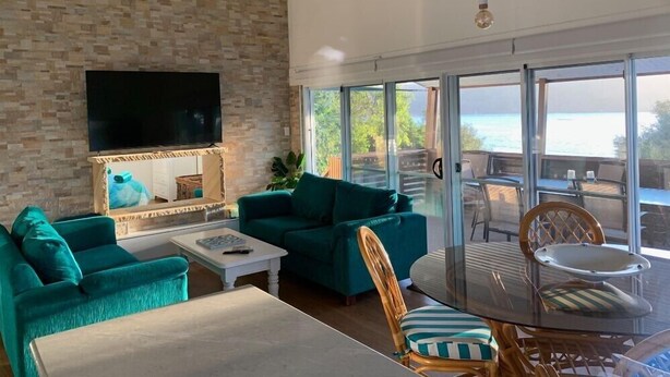 A living room with a TV, two sofas, a coffee table, and a dining table with chairs.