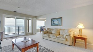 A living room with a sofa, a coffee table, a lamp, and a painting on the wall. - Lincoln City Condo: Pool Access, Walk to Beach! (Lincoln City)