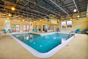 An indoor swimming pool with clear water, surrounded by blue chairs and a high ceiling with exposed beams. - Cozy Oregon Resort Condo - Steps to Lincoln Beach! (Lincoln City)