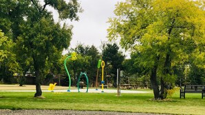 A park with green grass, trees, and colorful sculptures. - Langham Motel (Langham)