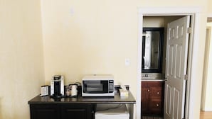 A compact kitchenette with a microwave, coffee maker, and a small refrigerator. - Langham Motel (Langham)