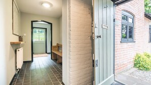 A hallway with a tiled floor, a bench, a door, and a brick wall. - ★Walnut Tree Cottage★ Huge garden+village setting+near Canterbury+dog friendly (Canterbury)