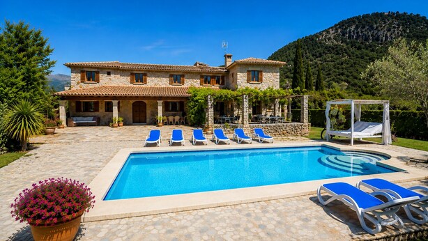 A pool with blue lounge chairs, a stone building with a tiled roof, and a mountainous backdrop. - Ca l'Apostol, Mallorca style villa with a swimming pool (Pollença)
