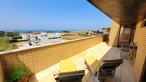 Un balcon avec vue sur la mer et les bâtiments environnants.
