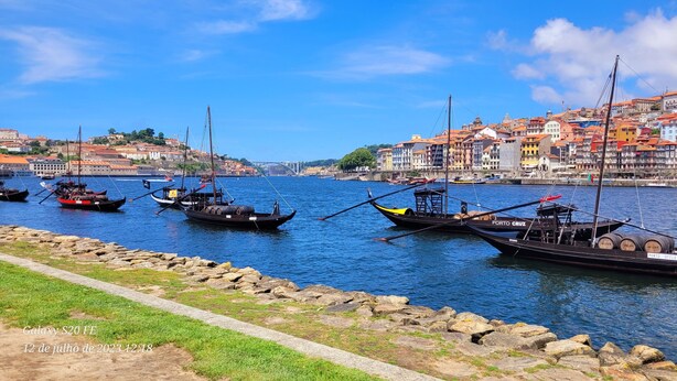 A harbor with boats docked, a stone wall, and buildings in the background. - Beach and City Getaway (Vila Nova de Gaia)