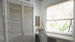 A room with a desk, a chair, a window with blinds, and a set of louvered doors. - Crew's Nest at Bayview Villas, Poolside Studio close to Grafton Beach (Black Rock, Pleasant Prospect)
