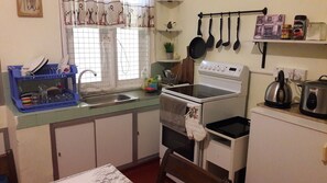 Compact kitchen with sink, stove, microwave, and ample storage.