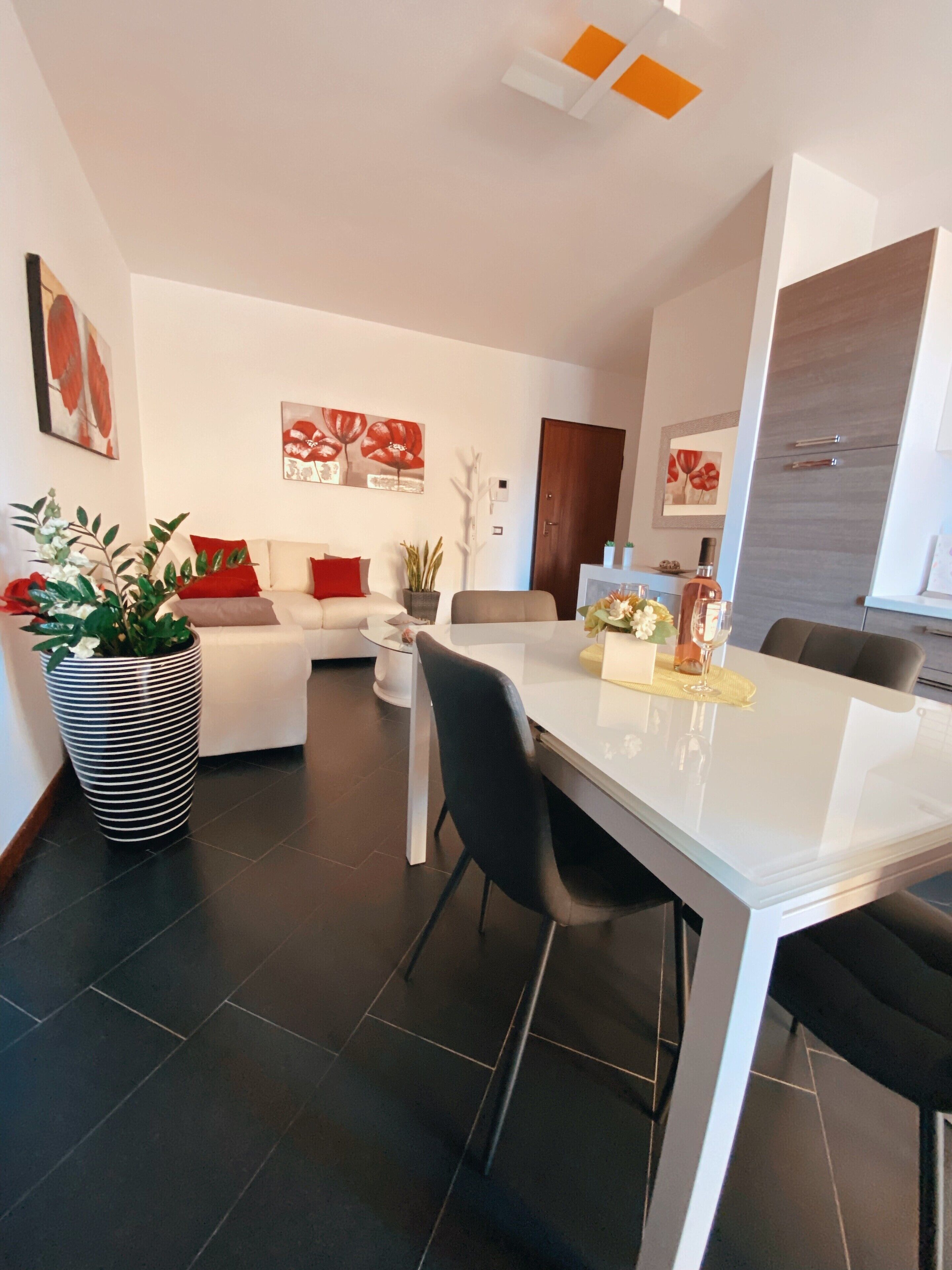 Un salon moderne comprenant un canapé, une table à manger et un coin cuisine.