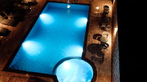 An indoor swimming pool with a circular hot tub, surrounded by lounge chairs and tables. - The Lake House Ko Yo (Songkhla)