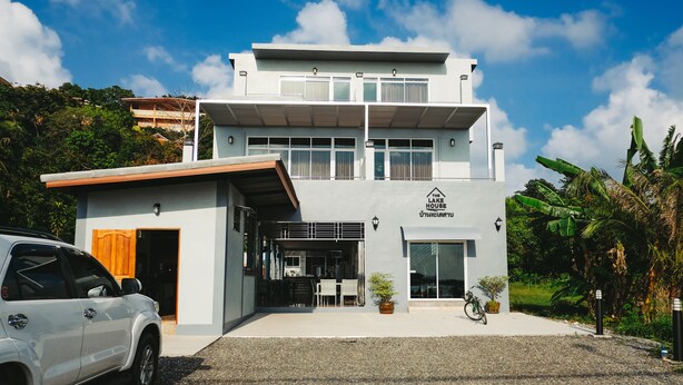 Un bâtiment moderne à deux étages, avec une façade blanche, une entrée couverte et une enseigne indiquant « The Life House ».