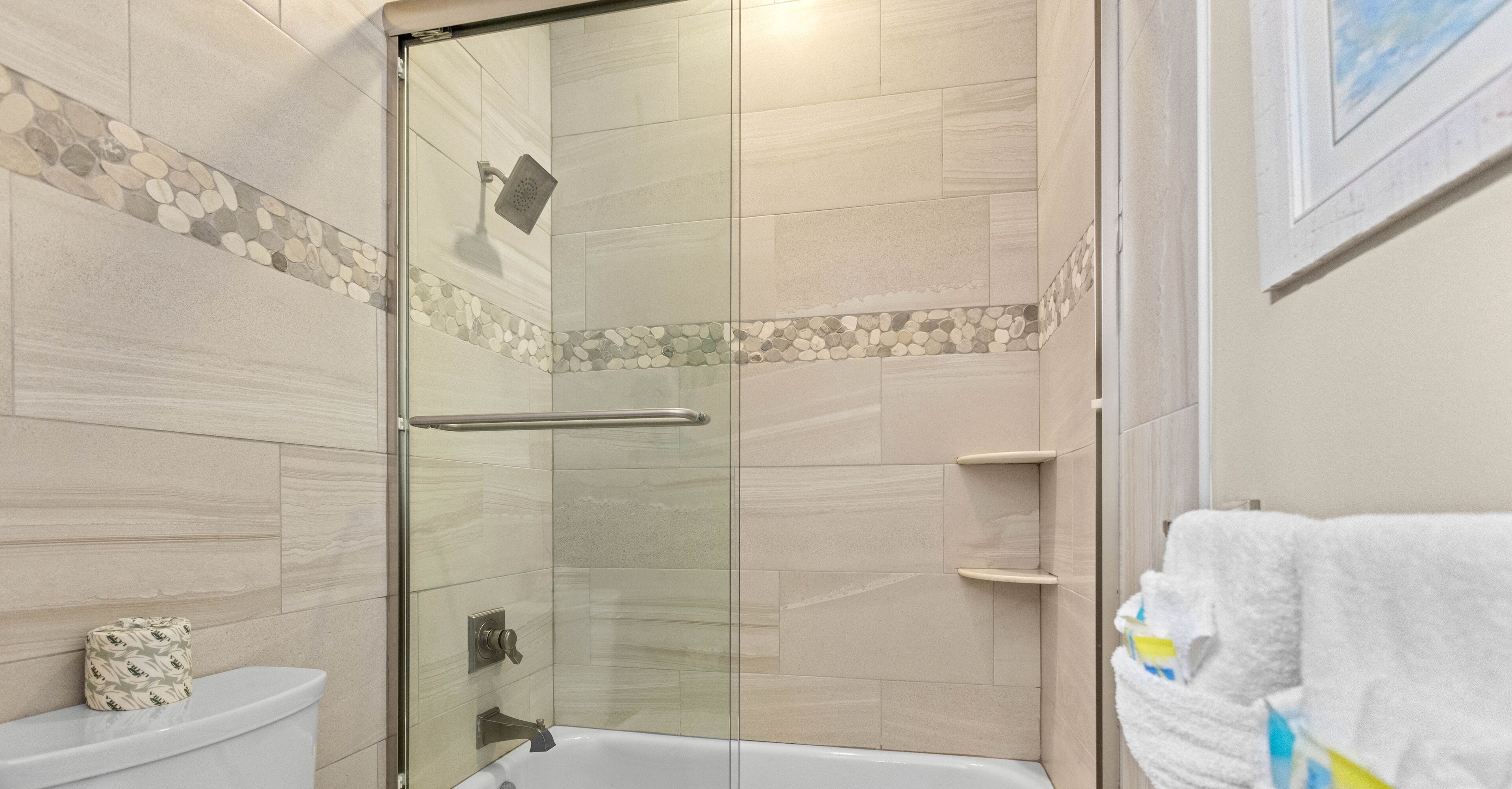 Un baño con cabina de ducha de vidrio, inodoro y bañera.