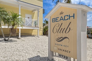 A sign for 'The Beach Club' with a vacancy indicator.