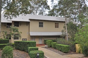 A two-story building with a flat roof, rectangular windows, and a front entrance with a door.